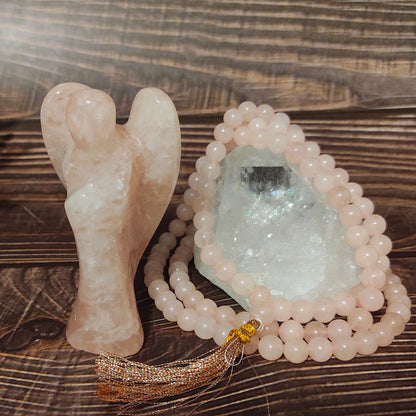 rose quartz mala prayer beads and angel figurine